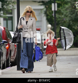 Gibt Claudia Schiffer nimmt ihren Sohn Caspar zur Schule.  Das Supermodel Sohn war für das nasse Wetter vorbereitet, wie er ist Stockfoto