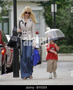 Gibt Claudia Schiffer nimmt ihren Sohn Caspar zur Schule.  Das Supermodel Sohn war für das nasse Wetter vorbereitet, wie er ist Stockfoto