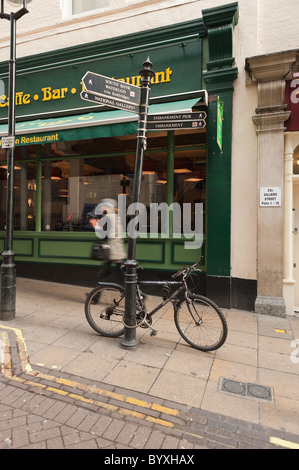 Tourist, vorbei an einem verketteten Fahrrad auf ein Schild Stockfoto