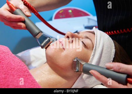 Frau, die eine anregende Gesichtsbehandlung von einem Therapeuten Stockfoto