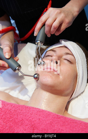 Frau, die eine anregende Gesichtsbehandlung von einem Therapeuten Stockfoto