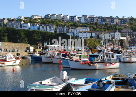 Angelboote/Fischerboote vor Anker im Hafen von Mevagissey, Häuser Cornwall, mit einer Kulisse aus Dorf auf dem Hügel. Stockfoto