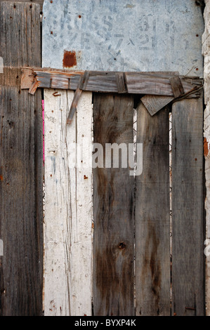 Alte hölzerne Scheunentor aus Planken und Schrott hergestellt. Hintergrundtextur. Stockfoto