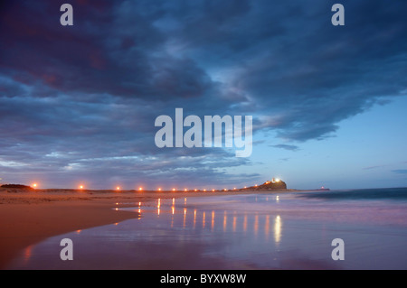 Wellenbrecher oder Steg führt zum Leuchtturm in der Nacht Stockfoto