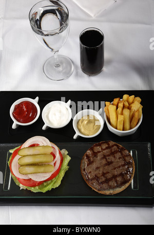 Burger und Pommes frites serviert auf einem klassischen Tisch Stockfoto