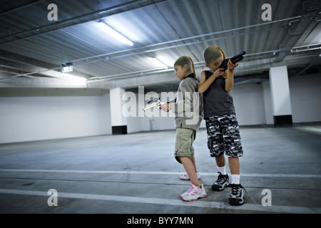 Kinder mit Strumpf Masken und Spielzeugwaffen in Tiefgarage vorzubereiten für große Bankraub. Stockfoto