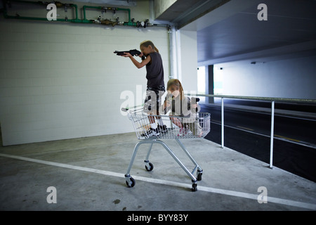 Kinder mit Strumpf Masken und Spielzeugwaffen in Tiefgarage vorzubereiten für große Bankraub. Stockfoto