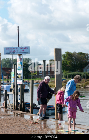 Kinder Angeln für Krabben auf der Seite Blakeney Hafen von Norfolk. Stockfoto