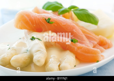 Spargel mit Lachs-Scheiben und Kartoffeln auf einem weißen Teller Stockfoto