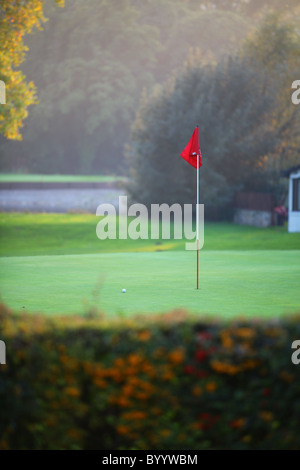 Golfplatz Loch im Herbst mit roten Fahnenmast Stockfoto