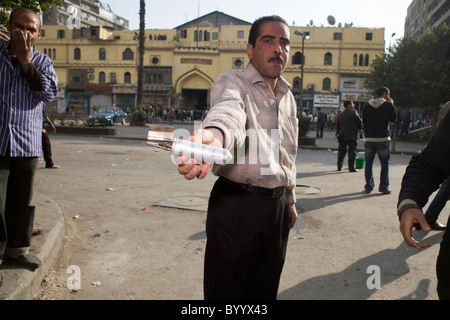 Ein Mann hält eine verbrauchte Tränengas-Behälter am Jan. 28, 2011 während der Anti-Regierungs-Proteste in der Innenstadt von Kairo, Ägypten Stockfoto