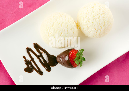 zwei Kugeln Vanilleeis, Erdbeeren in Schokolade Soße bedeckt Stockfoto