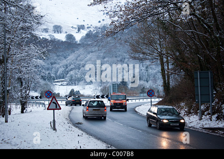 Autos fahren auf nassen Straßen im Winterschnee auf Zufahrtsstraße interchange Abergavenny Wales UK Stockfoto