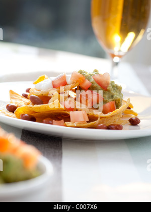 Frische Nacho-Chips mit Bohnen, Tomaten, Käse und guacamole Stockfoto