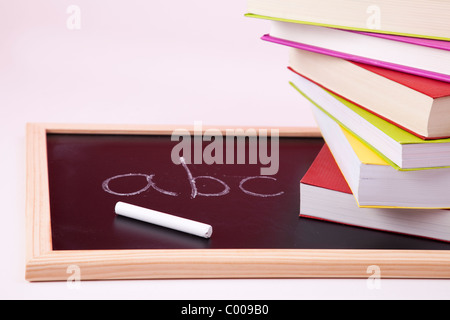 ABC Buchstaben geschrieben auf einer Tafel mit bunten Büchern (Tiefenschärfe) Stockfoto