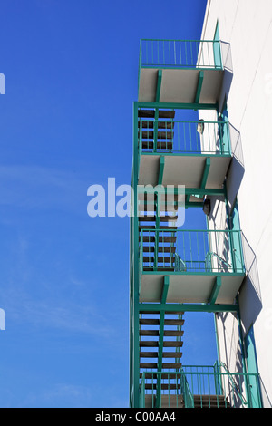Neue türkis grün Feuerleiter gegen strahlend blauen Himmel von hinten Treppe Stockfoto