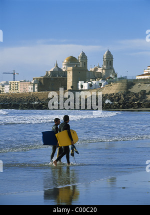 Surfer zu Fuß an Land vor der Kathedrale von Santa Cruz Stockfoto