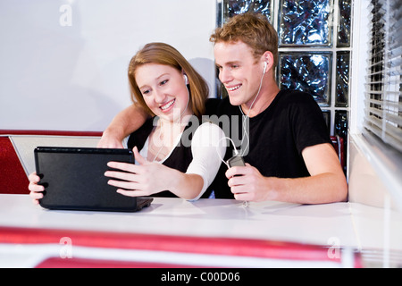 Moderne Teenager-Paar mit Technologie im diner Stockfoto