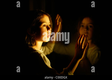 Mädchen in der Nacht mit Fenster Reflexion Stockfoto
