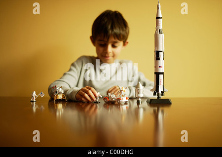 Junge mit Modell Apollo Saturn V Mondrakete, Astronauten, Mondmodul und Mondfahrzeug. Stockfoto