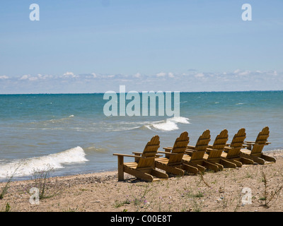 Adirondack Stühle aufgereiht am Strand mit Blick auf Lake Huron an einem schönen Sommertag. Stockfoto