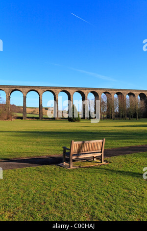 Holzbank im Wasser-Meadows-Park mit Blick auf die Eisenbahn-Viadukt, Penistone, South Yorkshire, England, UK. Stockfoto