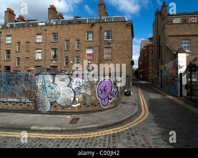 Die Rückseite aus einer Reihe von Reihenhäusern und Graffiti an einer gekrümmten Brick Wall Street Ecke in der Nähe von Brick Lane Grimsby St, East End, London England UK KATHY DEWITT Stockfoto