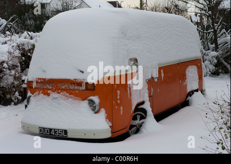 A unter orange Volkswagen Camper van geschneit Stockfoto