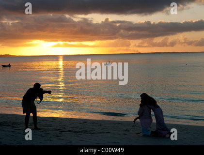 Fotograf und paar am Strand Stockfoto