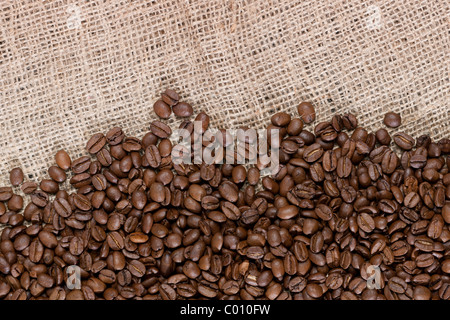Hintergrundbild von vielen Kaffeebohnen ergoss sich auf einer Leinwand-material Stockfoto