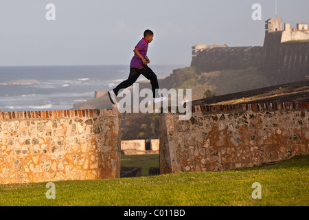 Ein kleiner Junge läuft entlang der alten Stadtmauer von San Juan, Puerto Rico. Stockfoto