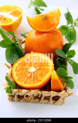 Segmenten Orange und orange und Minze in einem Weidenkorb Stockfoto