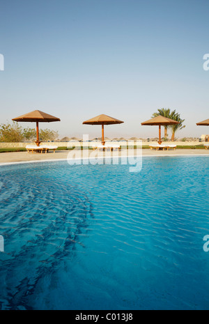 Pool mit einer blauen Wasseroberfläche, Sonnenliegen und Sonnenschirme, Soma Bay, Rotes Meer, Ägypten, Afrika Stockfoto