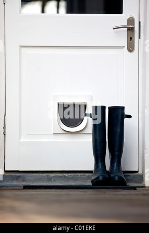 Ein paar Gummistiefel durch eine Tür Stockfoto