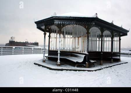 Viktorianische Pavillon im Schnee mit Fort Perch Rock im Hintergrund. Aufgenommen in New Brighton, Wirral, UK Stockfoto