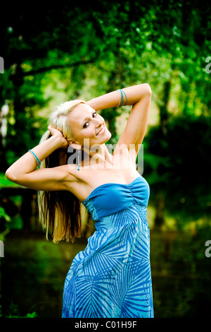 Junge Frau posiert auf einem Waldsee Stockfoto