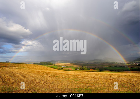 Blick über ein Stoppelfeld mit Regenbogen, Hegau-Region, Landkreis Landkreis Konstanz, Baden-Württemberg, Deutschland, Europa Stockfoto