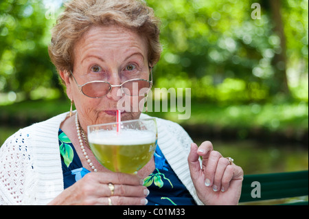 Alte Dame ein Glas Berliner Weisse, ein aromatisierter deutsches Bier trinken Stockfoto