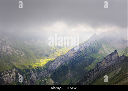 Stimmungsvolle Beleuchtung in den Appenzeller Alpen vor einem Sturm mit der Sonne auf die alpine Stadt Meglisalp Stockfoto