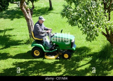 Älterer Mann Mähen des Rasens auf einem John Deere Sit-auf Rasenmäher, Bengel, Rheinland-Pfalz, Deutschland, Europa Stockfoto