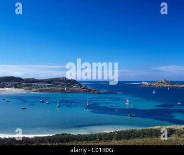 Klares blaues Meer umgibt die Insel Tresco, Isles of Scilly, Großbritannien. Der alte Hafen von Grimsby und das Island Hotel im Hochsommer Stockfoto