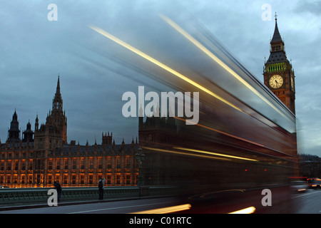 Einem roten Londoner Bus vorbei an The Houses of Parliament am Abend Stockfoto