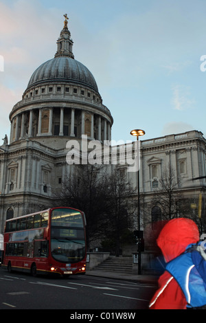 St. Pauls Cathedral mit einem roten London Bus vorbei und Teil eines Radfahrers hervorgehoben in der unteren rechten Ecke Stockfoto