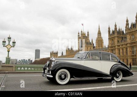 Ein Rolls-Royce Silver Wraith fährt vorbei den Houses of Parliament in London, England Stockfoto