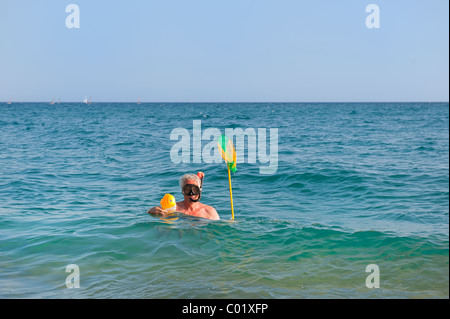 Mann steckt ein Zierfisch im Meer beim Schnorcheln Stockfoto