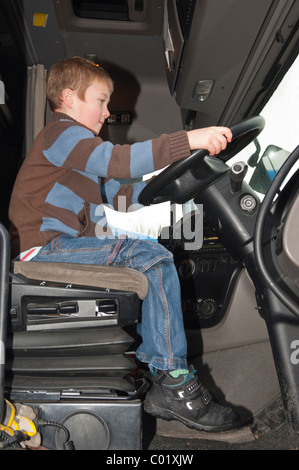 Ein MODEL Release sieben Jahre alter Junge sitzt in einem LKW-LKW-Kabine im Vereinigten Königreich Stockfoto