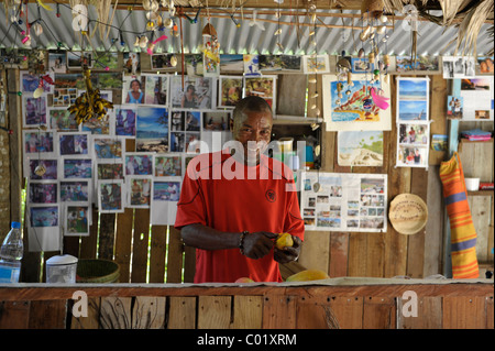 Lächelnd dunkle dunkelhäutigen Mann an Strandbar, La Digue, Seychellen Stockfoto