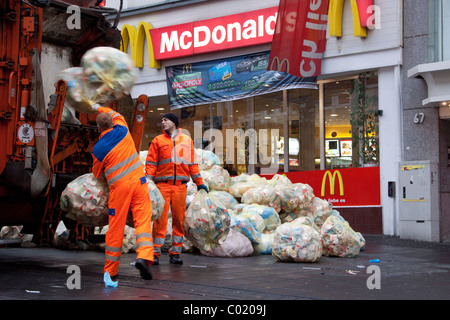 Müllsäcke mit Abfallverpackungen stapelten sich auf der Straße Werden von außerhalb eines McDonald's Fast-Food-Restaurants weggebracht Müllsammler / Müllmänner Stockfoto