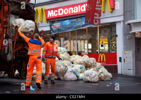 Müllsäcke mit Abfallverpackungen stapelten sich auf der Straße Werden von außerhalb eines McDonald's Fast-Food-Restaurants weggebracht Müllsammler / Müllmänner Stockfoto