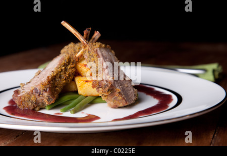 Lammrücken mit Gemüse auf Holztisch Stockfoto